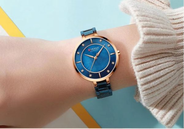 CURREN 9051 Women's Quartz Dress Watch - Golden White Blue watch with rose-gold accents on a wrist