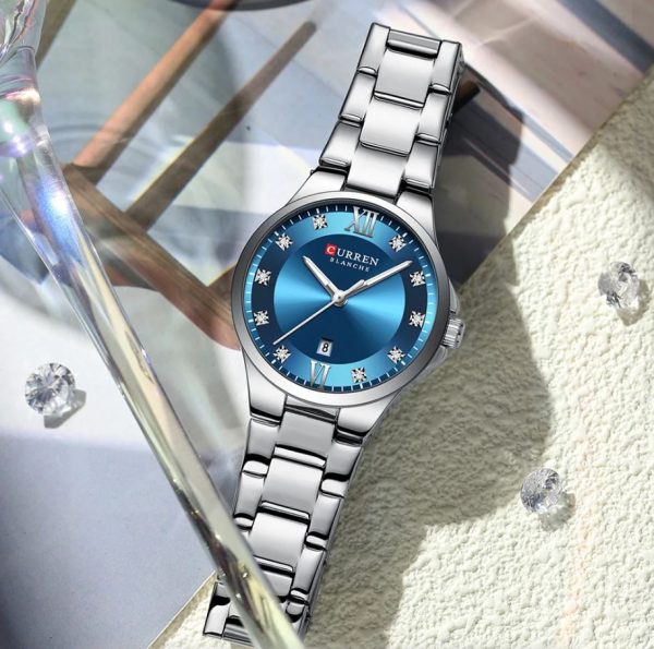 CURREN 9107 Women's Analog Quartz Watch - Silver Blue Silver watch with a blue face on a textured surface